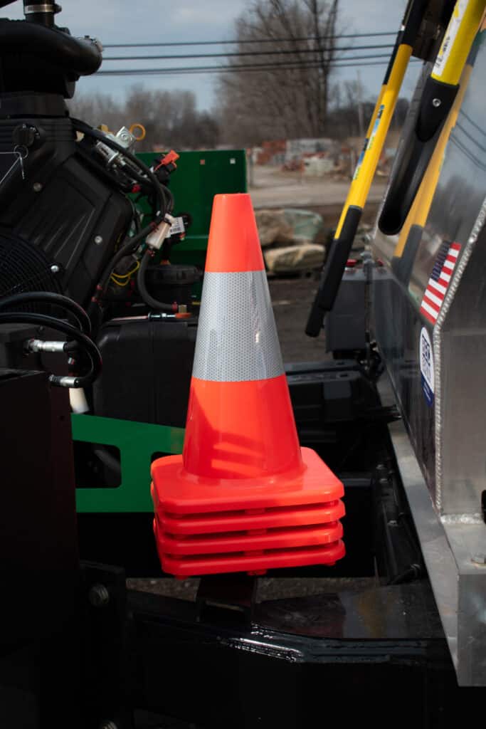 Traffic cones stacked beside a vehicle, essential for Mulch Mule contractor setups.
