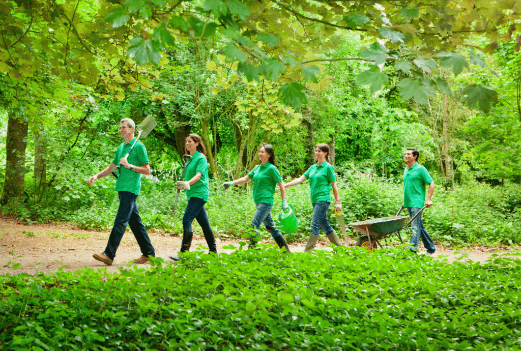 Community gardening team walking through a green space, ready for planting activities.