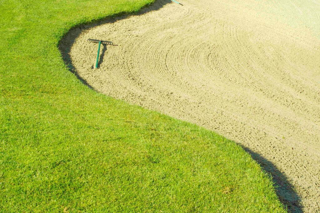 Vibrant golf course landscape featuring lush grass and a sandy bunker.