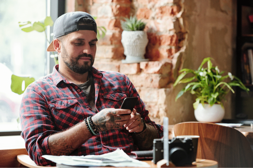 Man using smartphone to review customer feedback of his business on social media