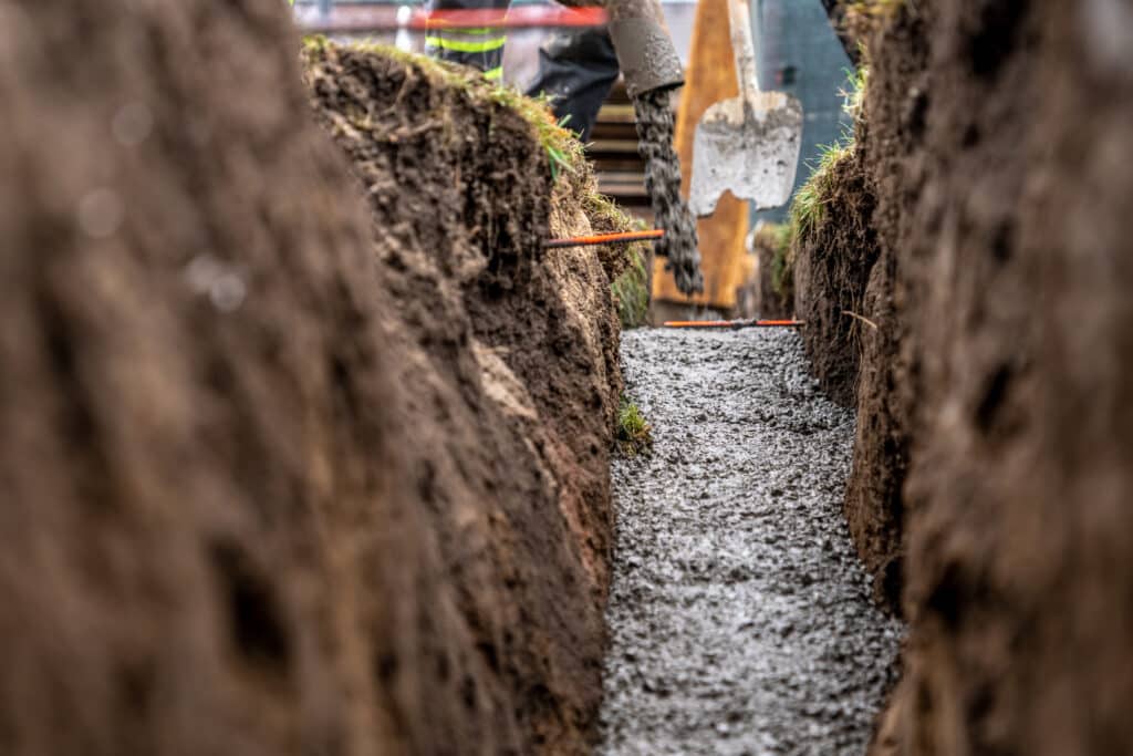 Foundation trench filled with concrete during building construction process.