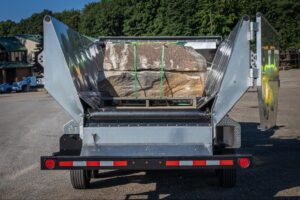 Heavy stone slabs loaded in a dump trailer ready for transport.