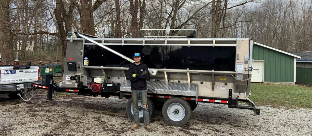 Mulch Mule trailer with business owner standing proudly in front of it.