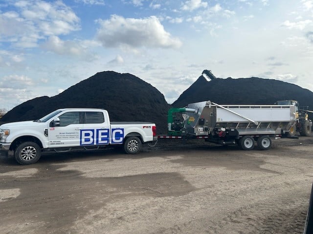 BEC truck transporting mulch near large piles using the Mulch Mule mulch machine.
