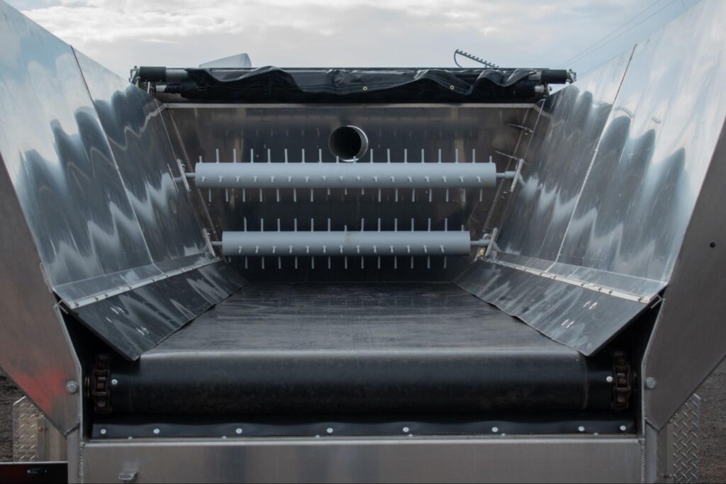 Mulch dispenser equipment with an open metallic hopper for efficient material loading and dispensing.