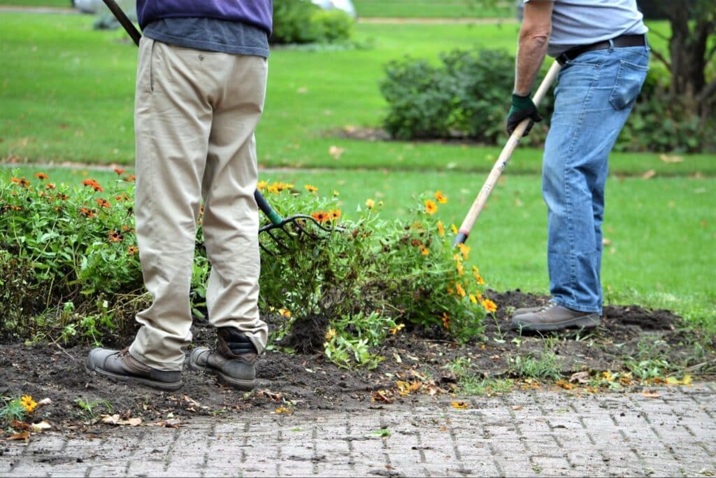 Gardeners planting flowers and maintaining landscaping for a vibrant outdoor space using the 5S methodology