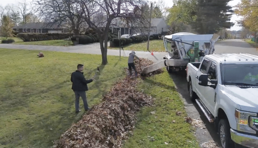 Fall leaf cleanup with workers and Mulch Mule trailer on a suburban street.