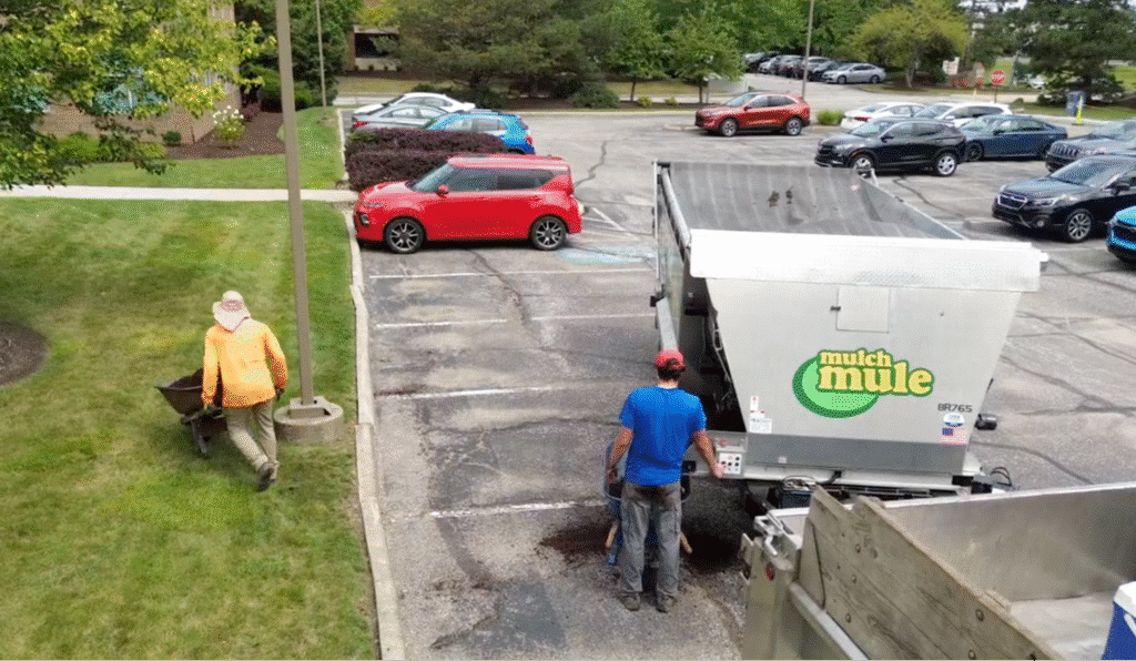 Landscape workers using a truck for yard maintenance in a residential area conveying local landscaping marketing with branded trailer.