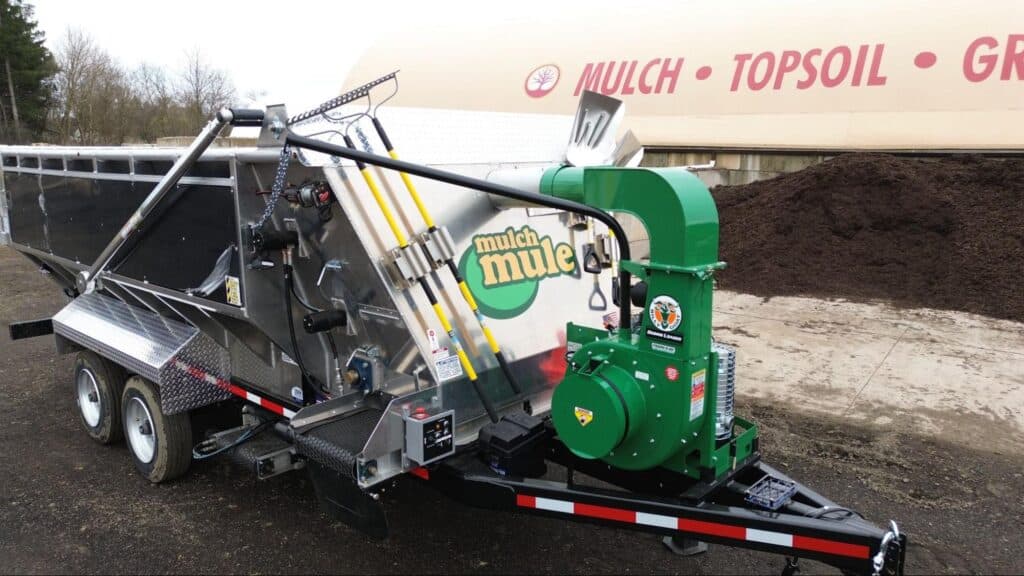 Mulch trailer with industrial equipment for efficient landscaping and soil management.
