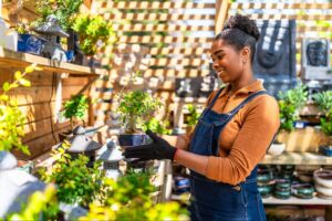 Woman tending to plants in a cozy garden shop.