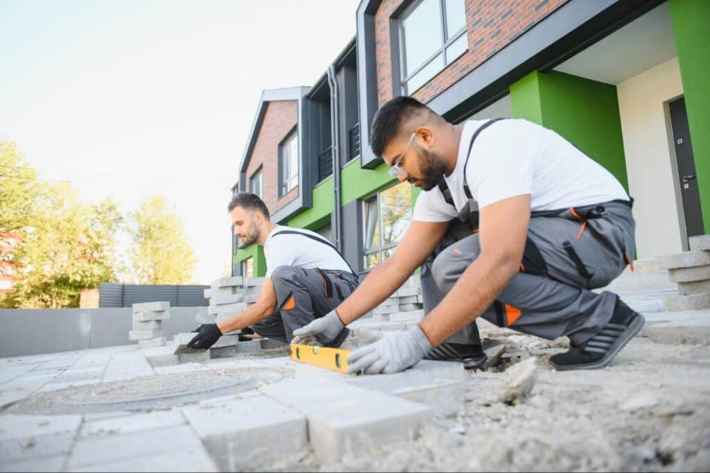 Masons expertly crafting a stunning outdoor patio with precision and care.