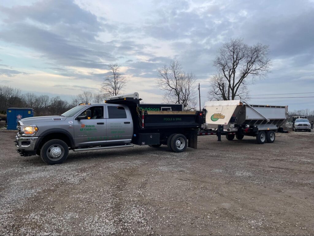 Heavy-duty truck towing a Mulch Mule trailer at a construction site.