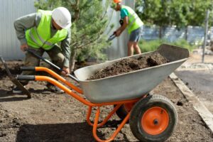 Landscapers enhancing gardens with wheelbarrows and tools for beautiful outdoor spaces.