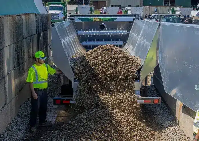 Rock hauler truck unloading gravel at a construction site, showcasing heavy equipment operations.