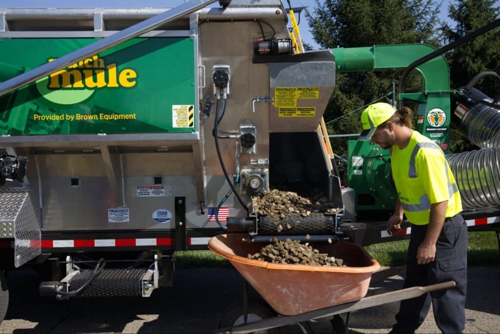Worker utilizing the Mulch Mule for efficient landscaping material processing.