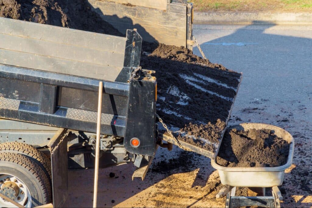 Dump trailer delivering soil for gardening and landscaping projects.