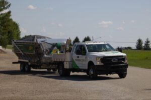 Durable truck towing equipment for landscaping on a rural road.