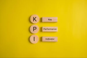 Key Performance Indicators represented by wooden letters on a vibrant yellow background.