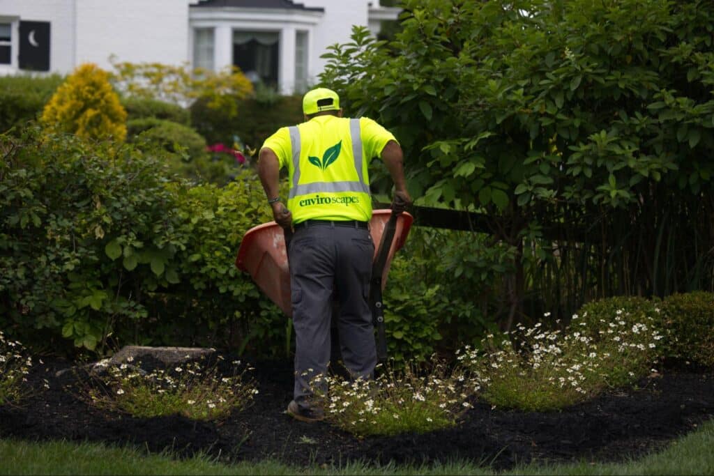 Expert gardener enhancing landscapes with a wheelbarrow, creating beautiful outdoor spaces.