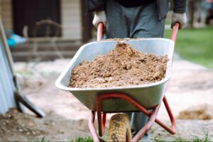 Transferring soil in a wheelbarrow for gardening and landscaping projects.