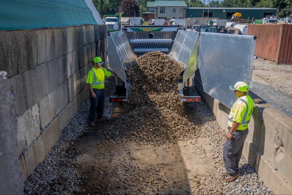 Workers unloading gravel at a construction site for ongoing projects.